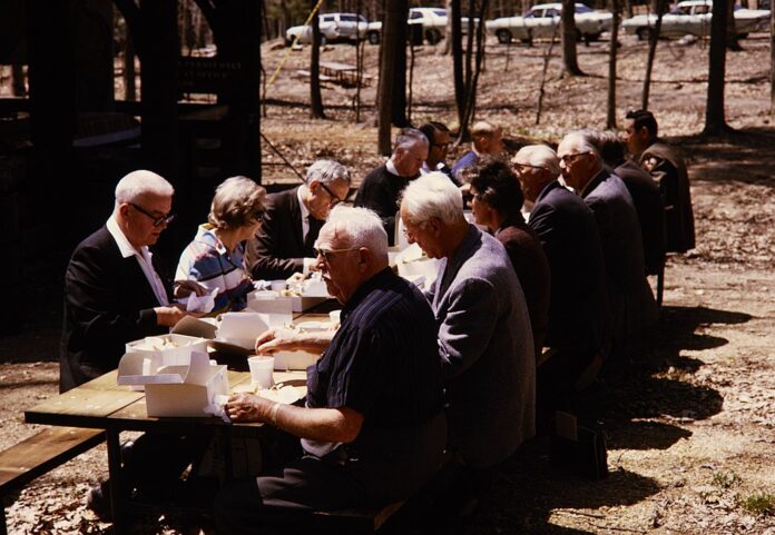 white men and women at a picnic table