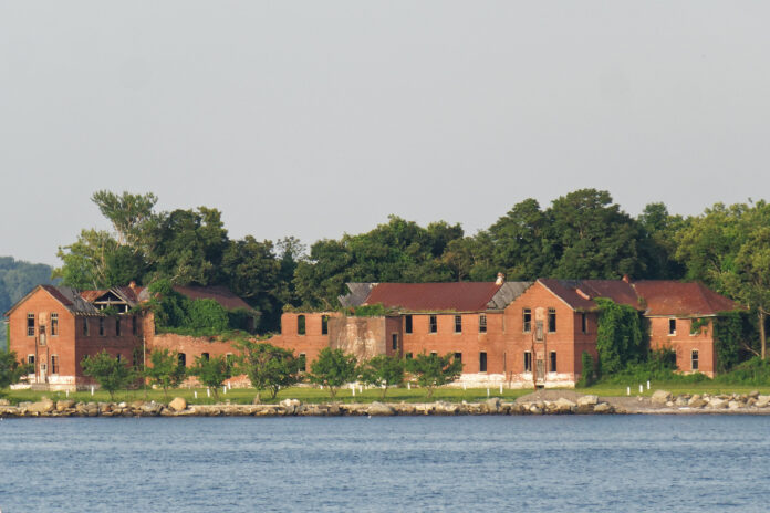 Decaying red brick buildings seen across the water from Bronx, New York