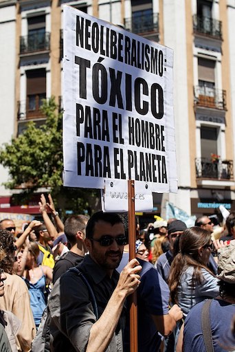 person holding banner at a demonstration in Madrid
