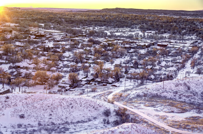 The suburbs of a town in winter. In foreground, what is currently waste land, awaiting development.
